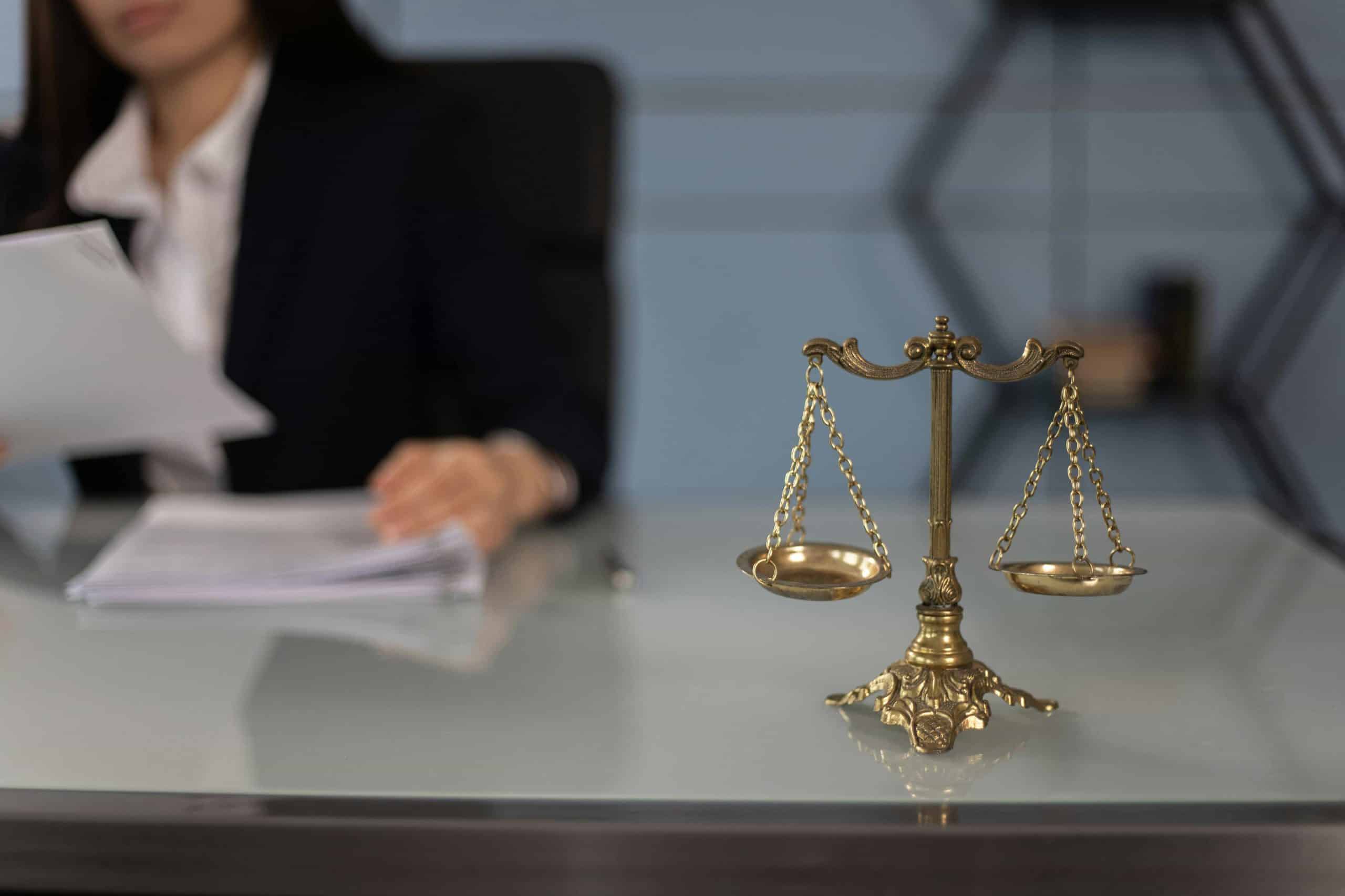A foreclosure attorney in a business suit sits at her desk